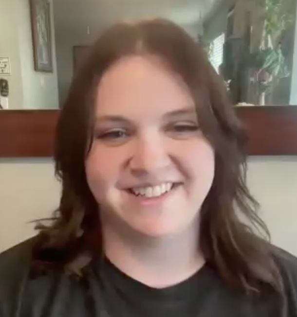 woman with dark hair smiling in black shirt