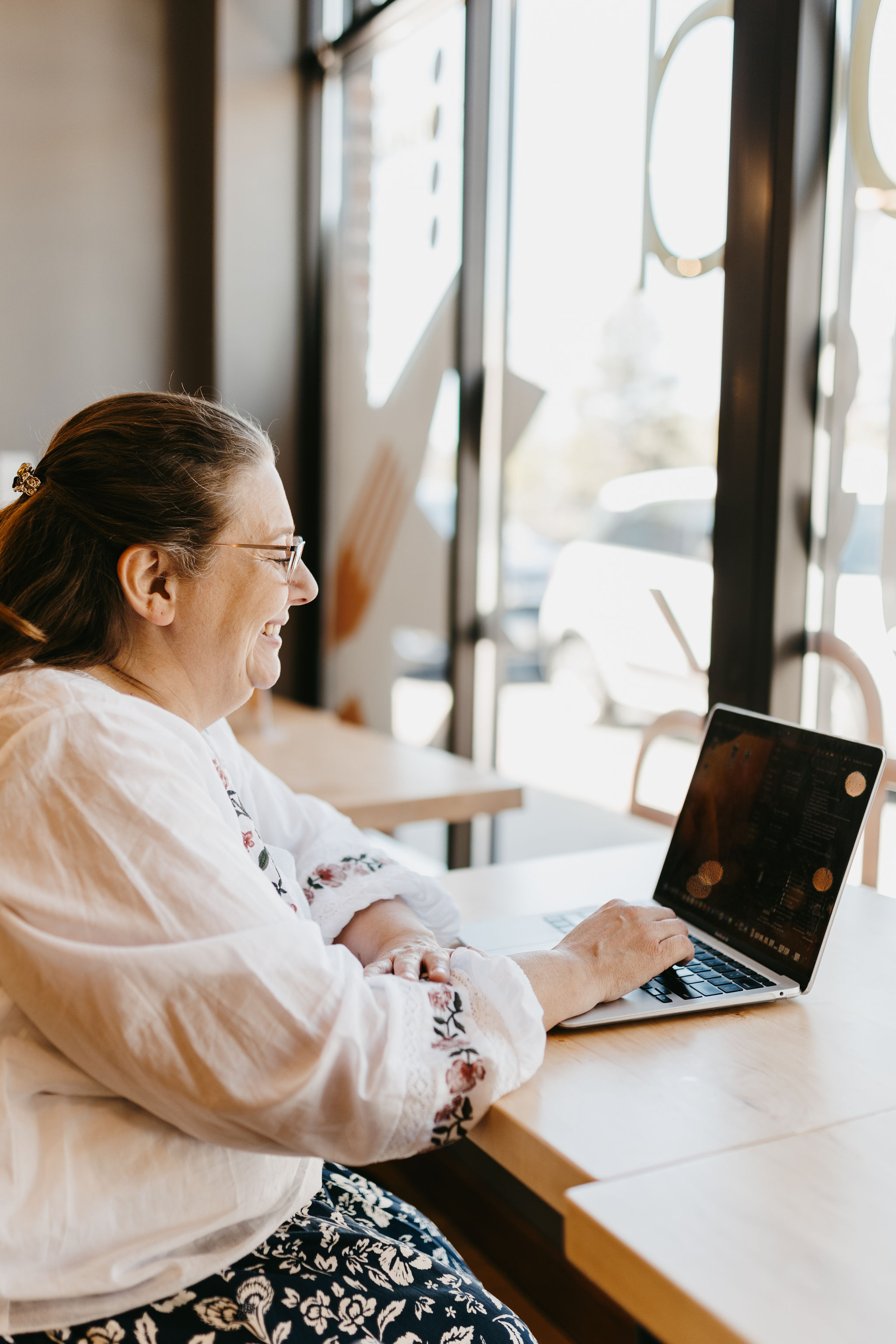 woman working on laptop with white blouse